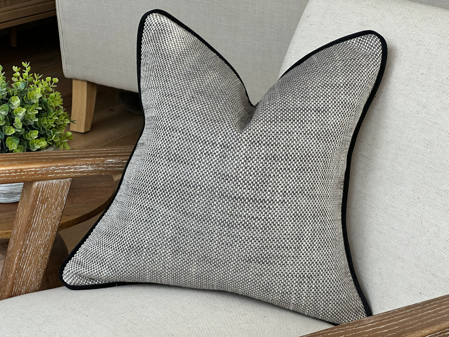 Modern grey pillow with trim.
