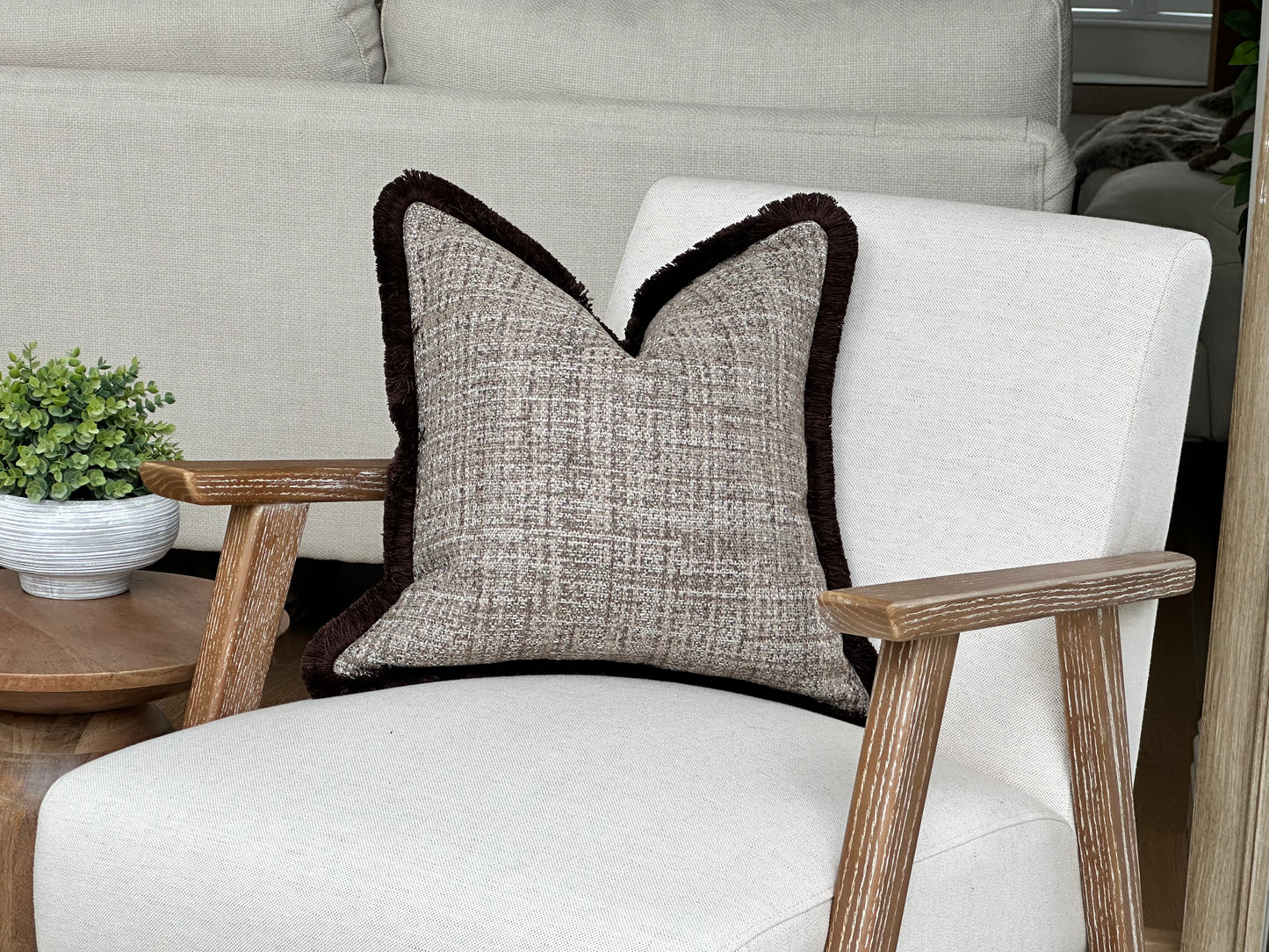 Brown textured cushion with brown fringe.