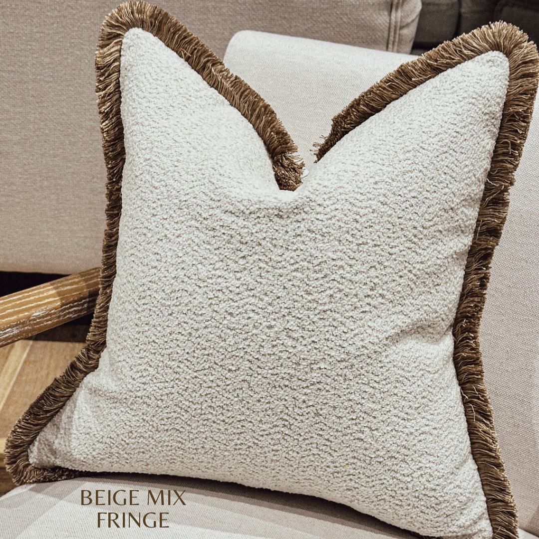 Boucle cushion with beige fringe.