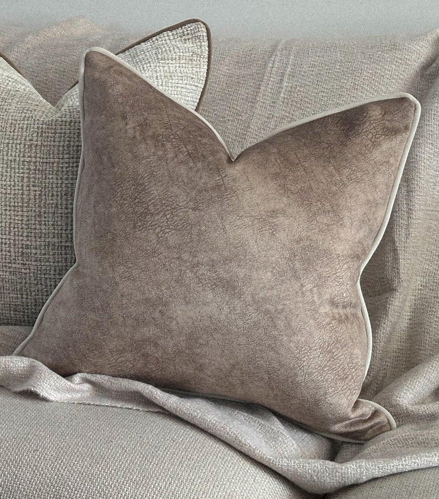 Beige textured look cushion cover with ivory piping.