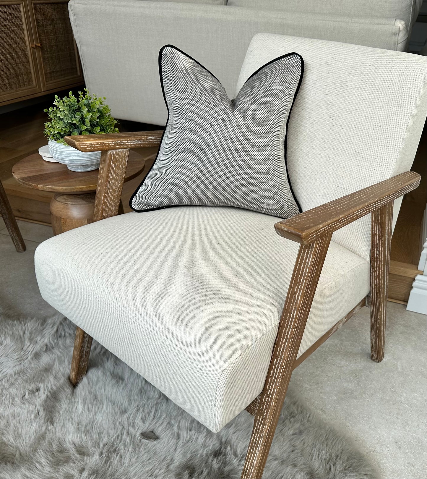 Textured grey cushion with black contrast piping
