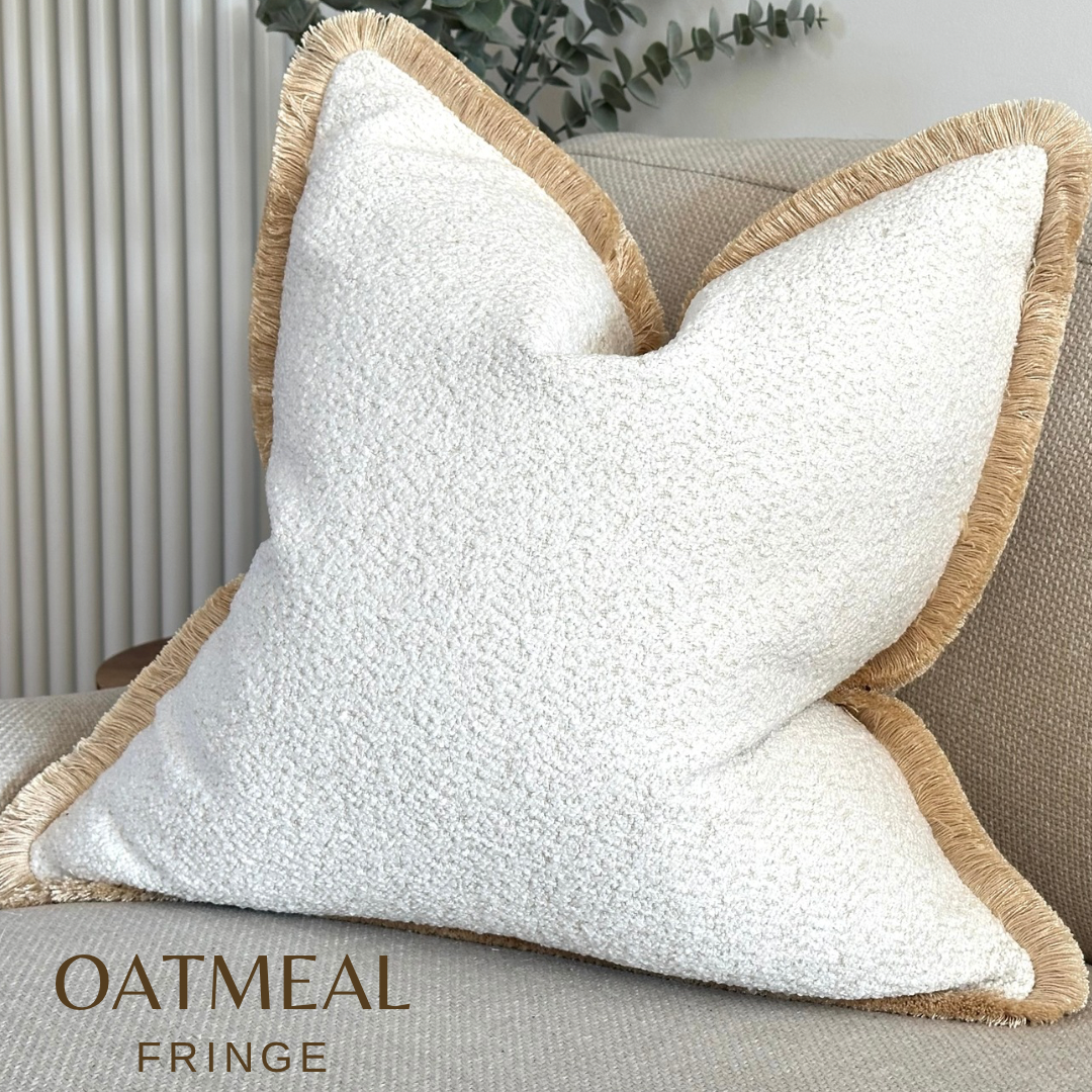 Luxury Ivory white boucle cushion with fringe trim.