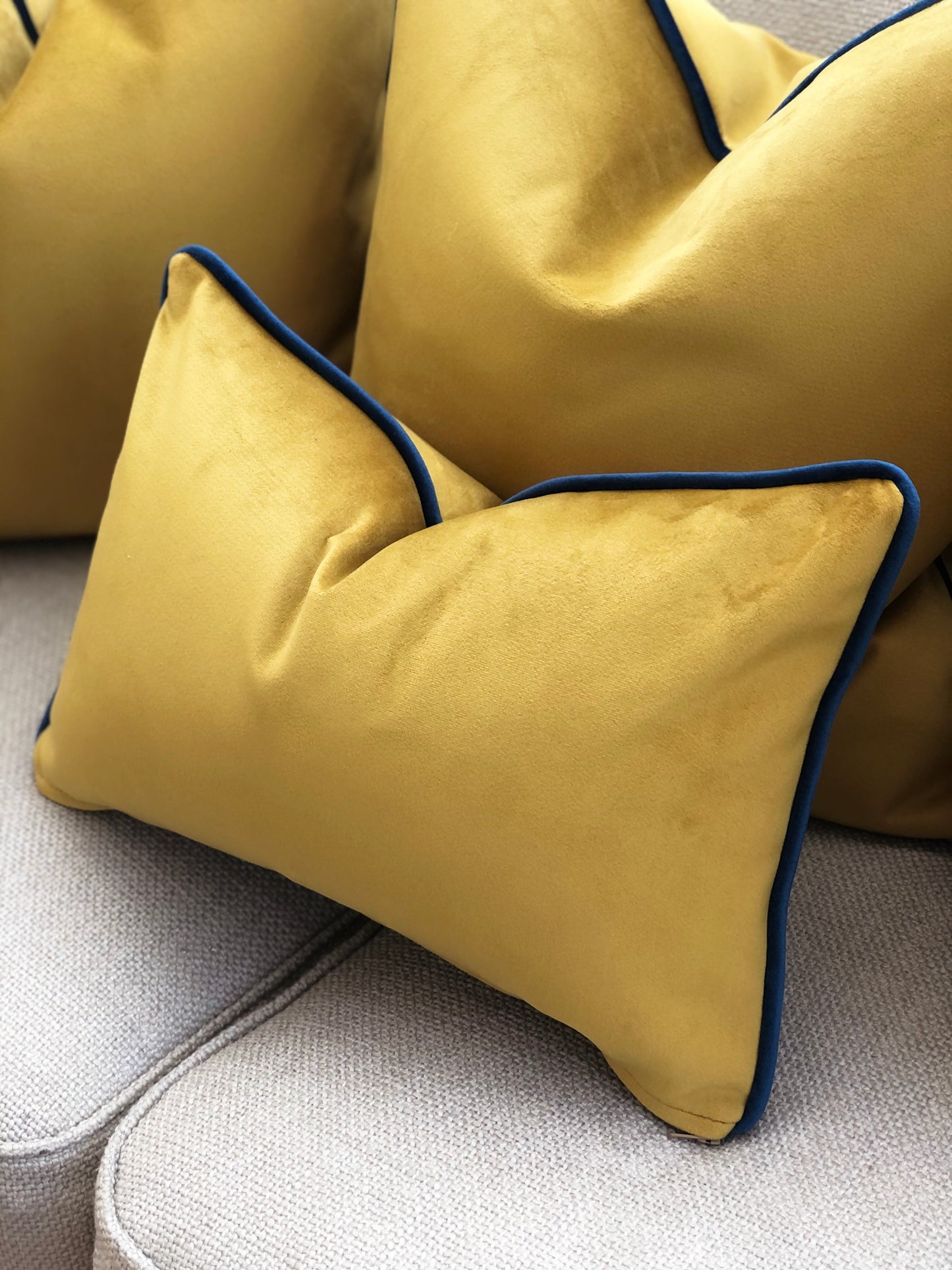 gold scatter cushion with blue trim