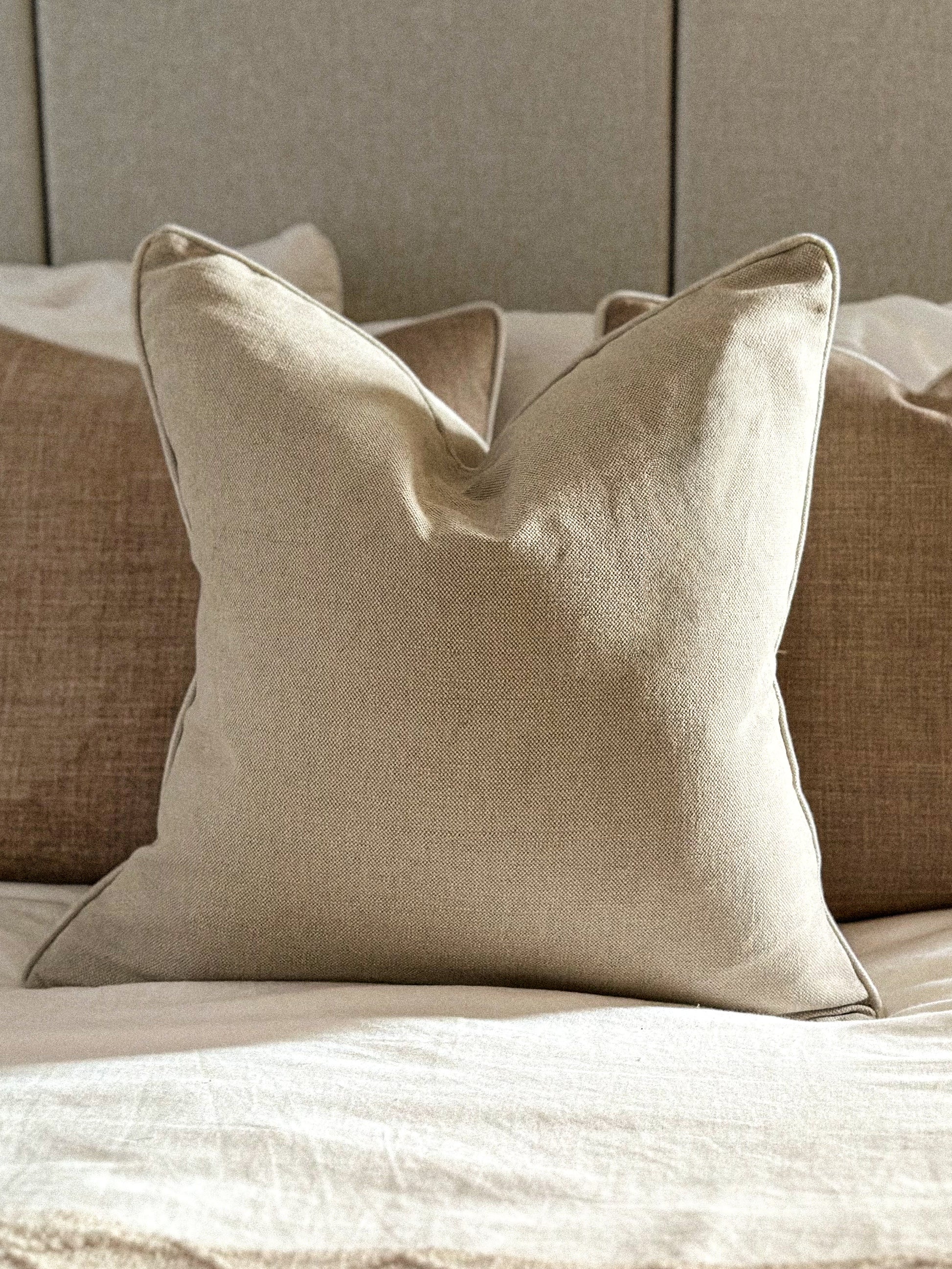 Soft stone pillow cover adding a natural, calming touch to a neutral bedroom.