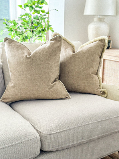 Warm neutral scatter cushion in a soft woven fabric on a cream sofa.