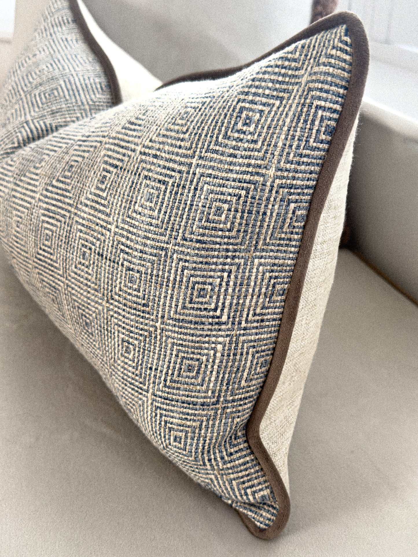 Close up of a blue patterned rectangle cushion.