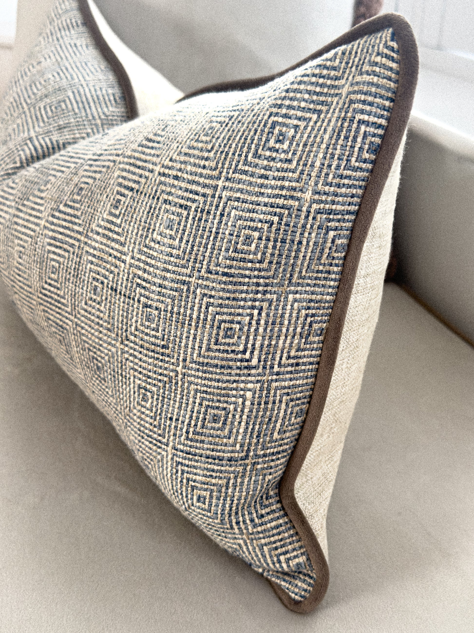 Close up of a blue patterned rectangle cushion.