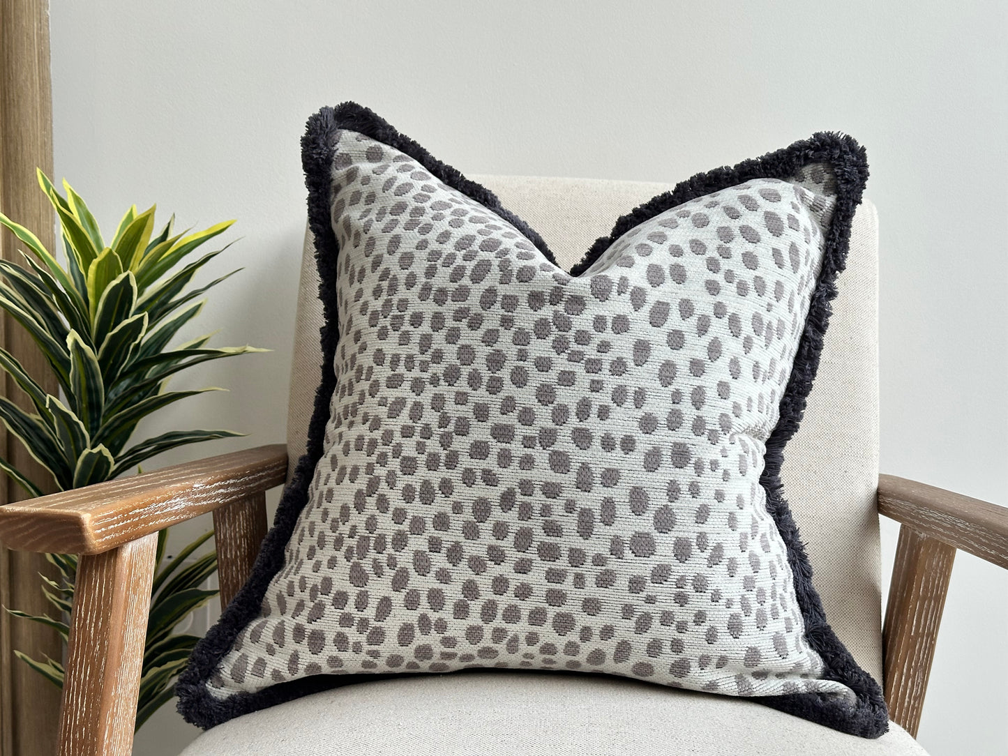 Grey and white print pillow with fluffy edge.