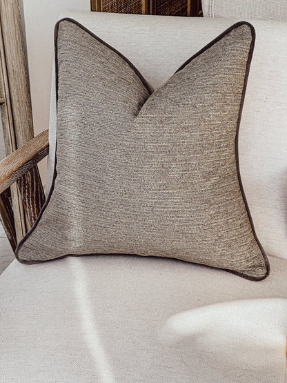 Beige textured pillow cover with bespoke trim.