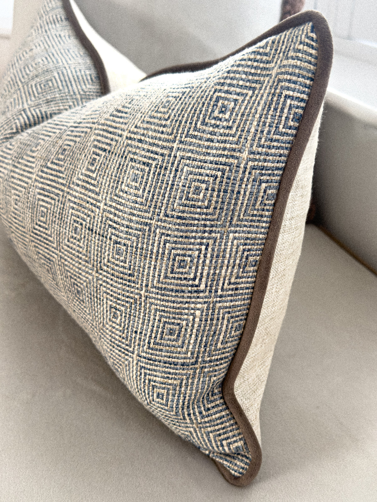 Close up of a blue patterned rectangle cushion.