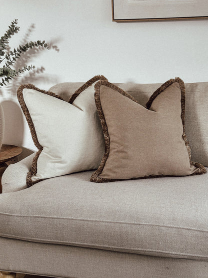Neutral luxury fringed cushions.