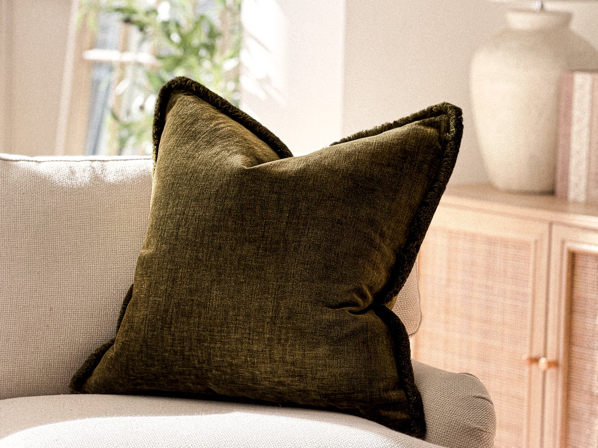 Deep olive green fringed cushion.