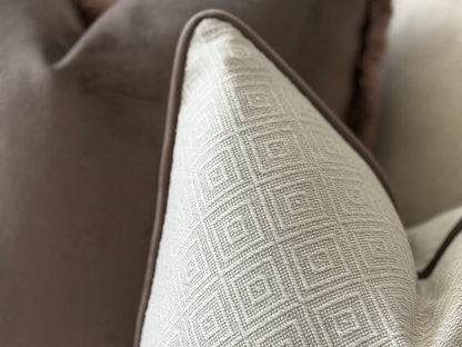 an ivory geometric cushion with brown edging