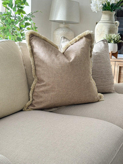 beige cushion cover styled with fringe trim for a cosy layered look.