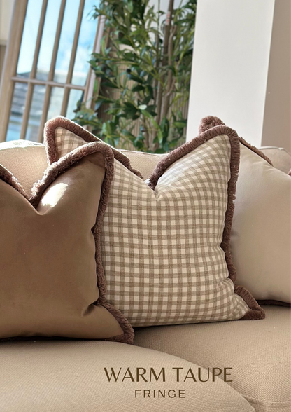 Beige gingham check farm house style cushion with a fringe trim.