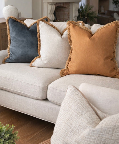 Honey mustard gold cushion along side a natural and aqua cushion all with antique gold fringe. This tree gives a luxury look.