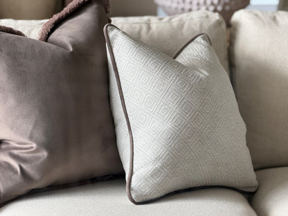 Natural ivory geometric cushion with brown piping