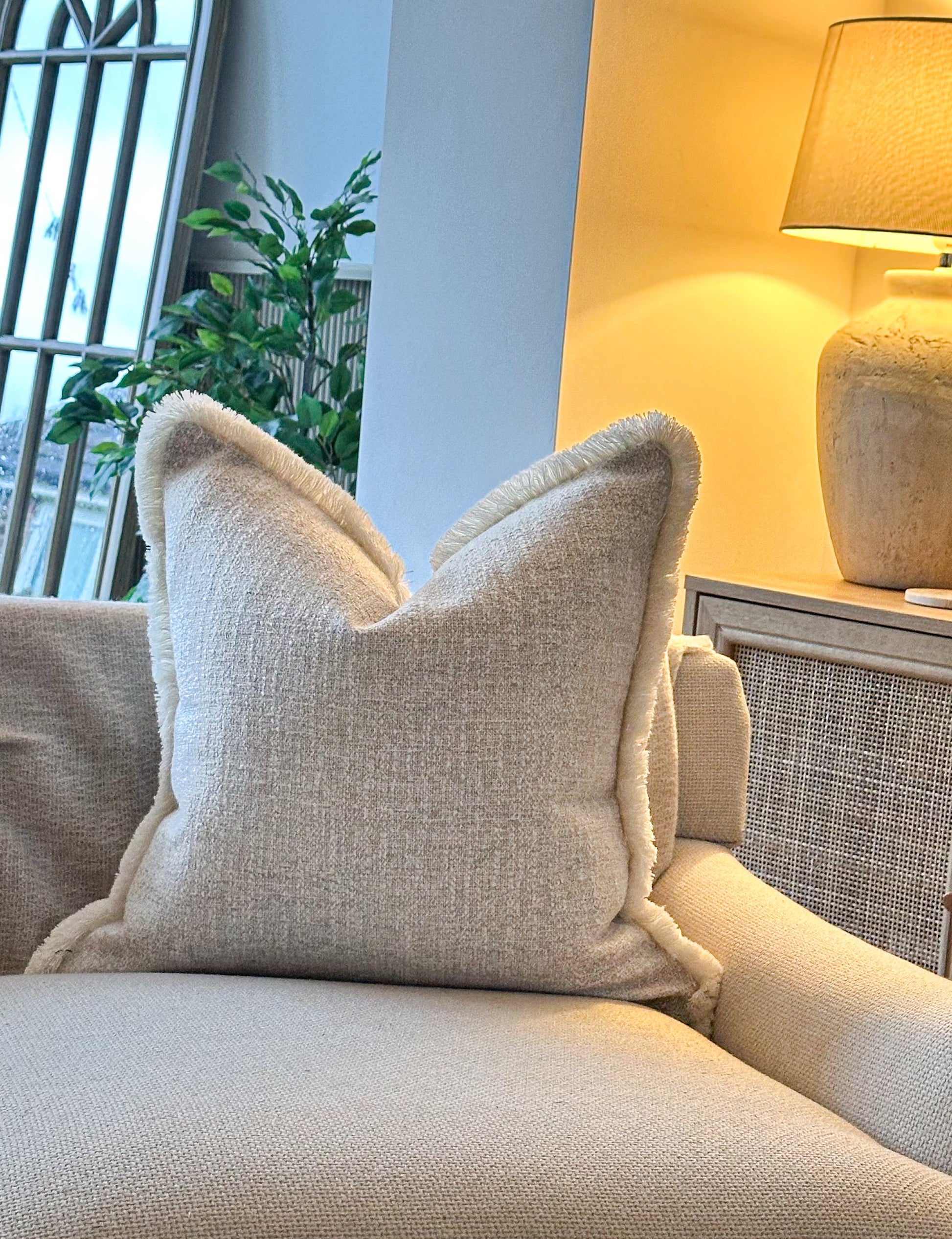 Textured beige fabric cushion with soft fringe trim — perfect for neutral, cosy home déc
