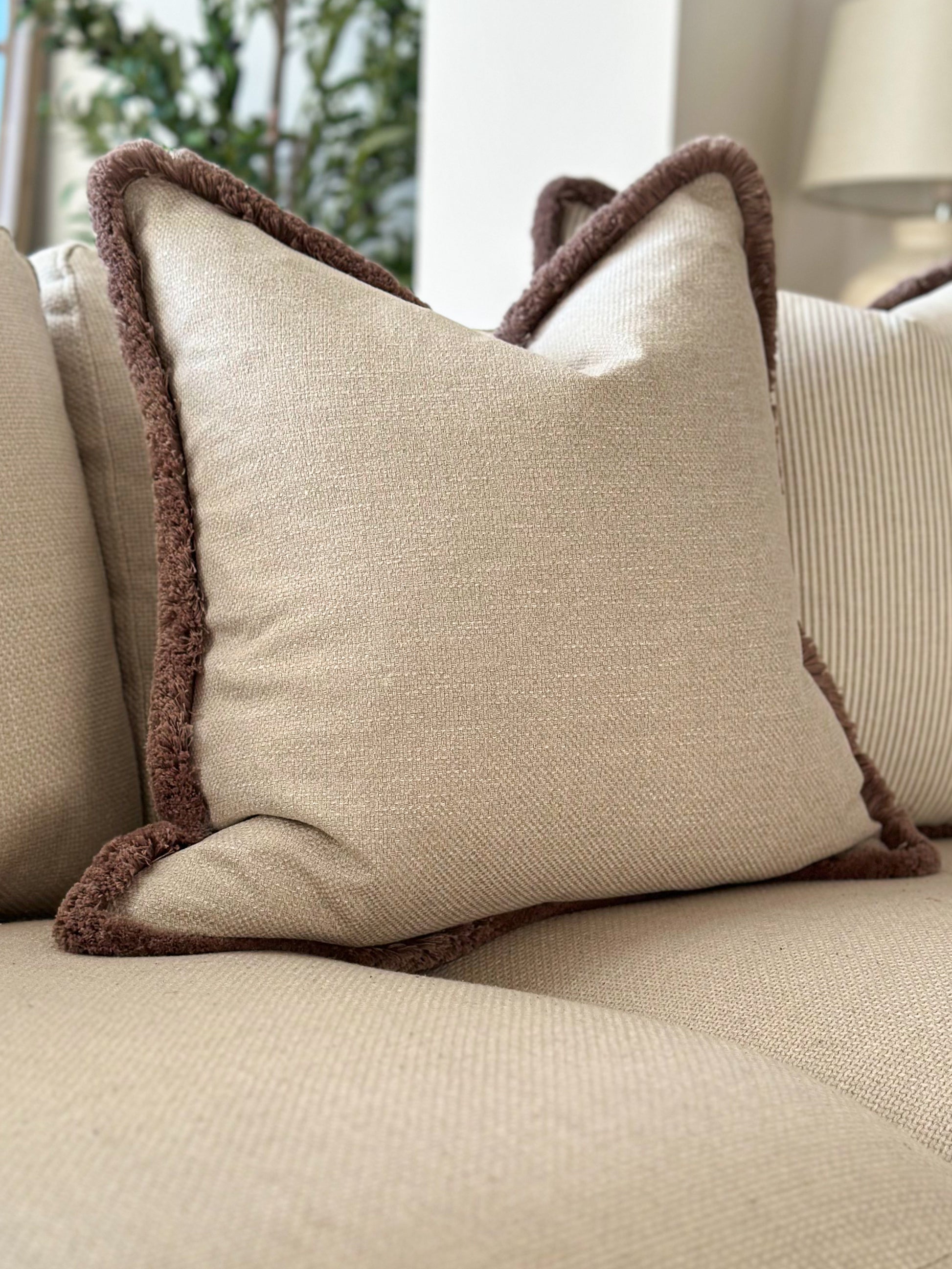 Warm grey textured cushion with fringe trim